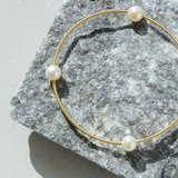 Pulsera guaya en oro amarillo con tres perlas
